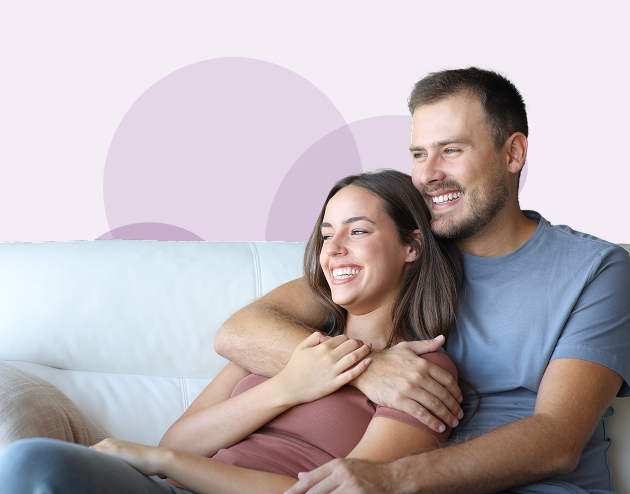 Smiling couple relaxing on a sofa after moving home.